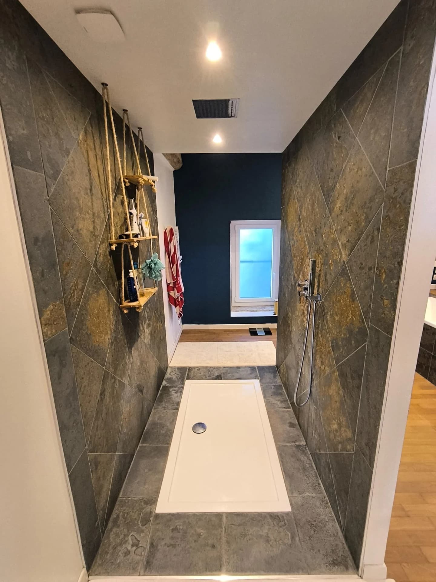 Douche à l’italienne avec carrelage sombre et robinetterie dorée