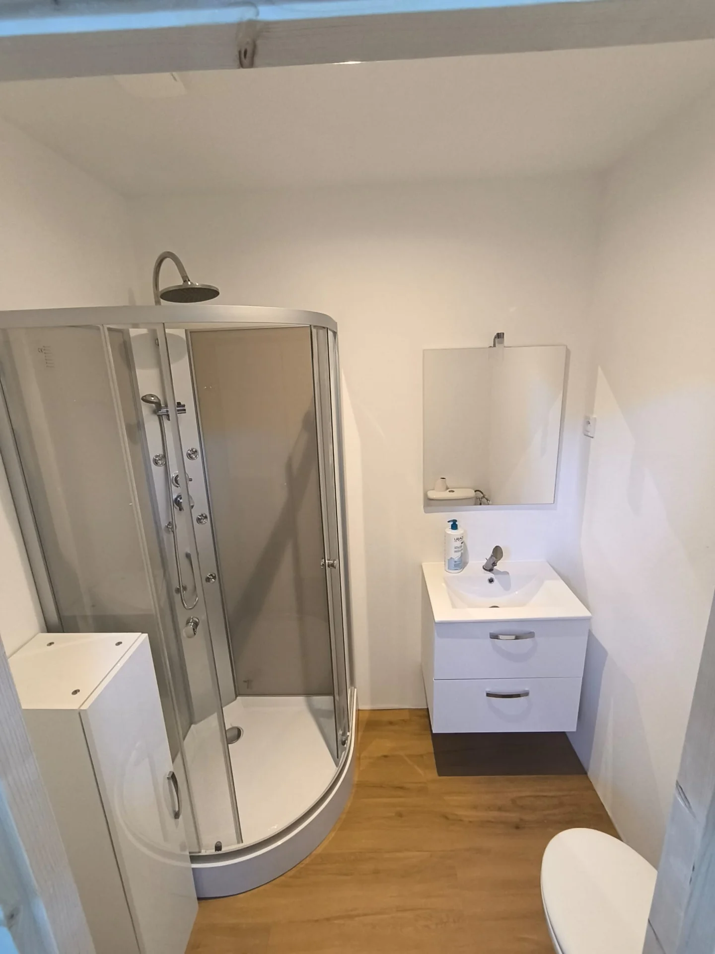 Salle de bain sous pente avec douche vitrée et meuble vasque