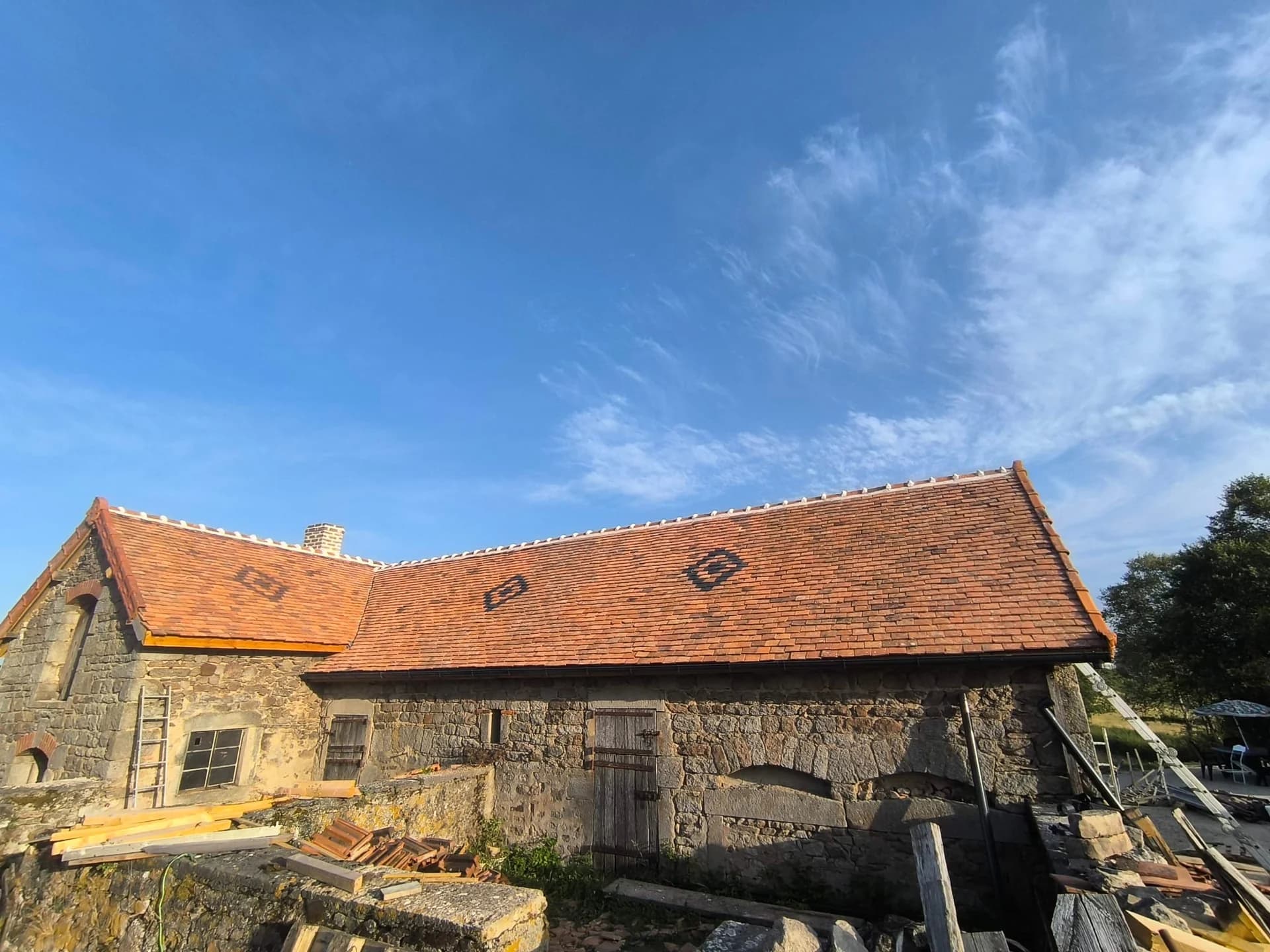Bâtiment en pierre avec toiture en tuiles et motifs losanges